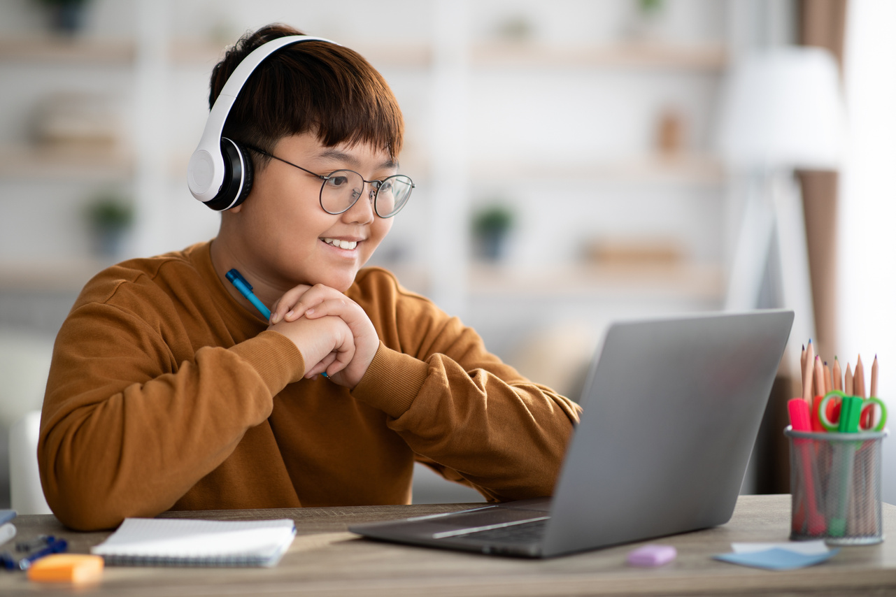 Cheerful Asian Boy Schooler Having Online Lesson from Home